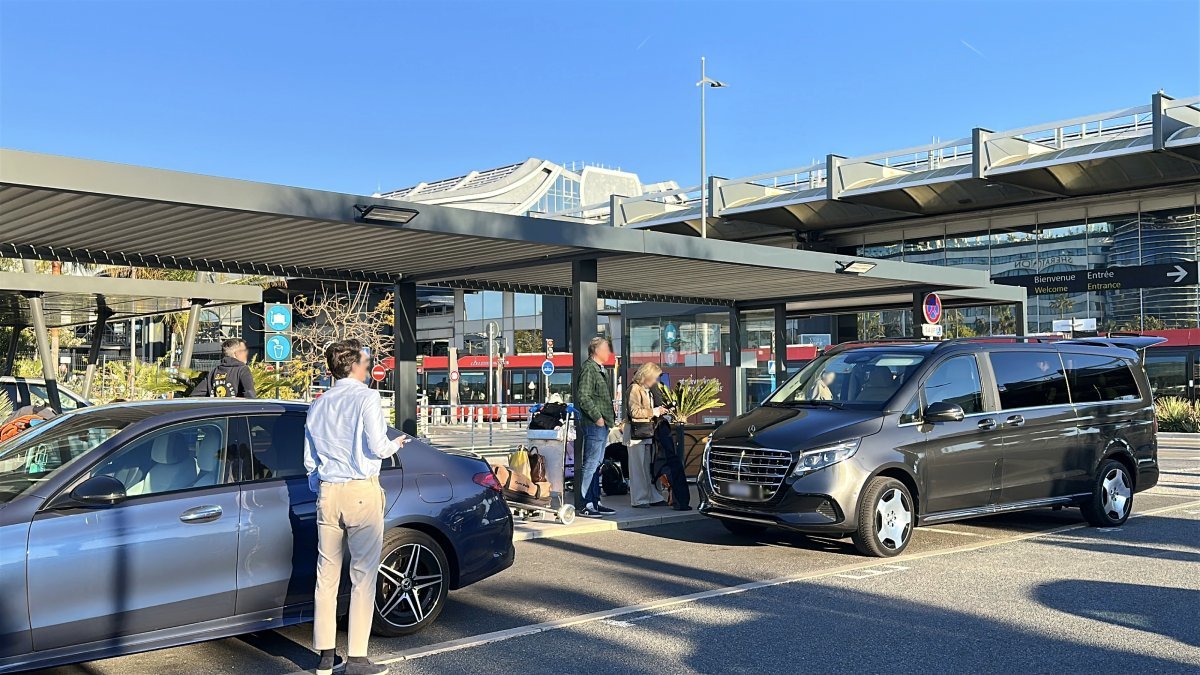 Водитель ожидает пассажиров возле автомобиля в аэропорту Ниццы для аренды автомобиля с водителем