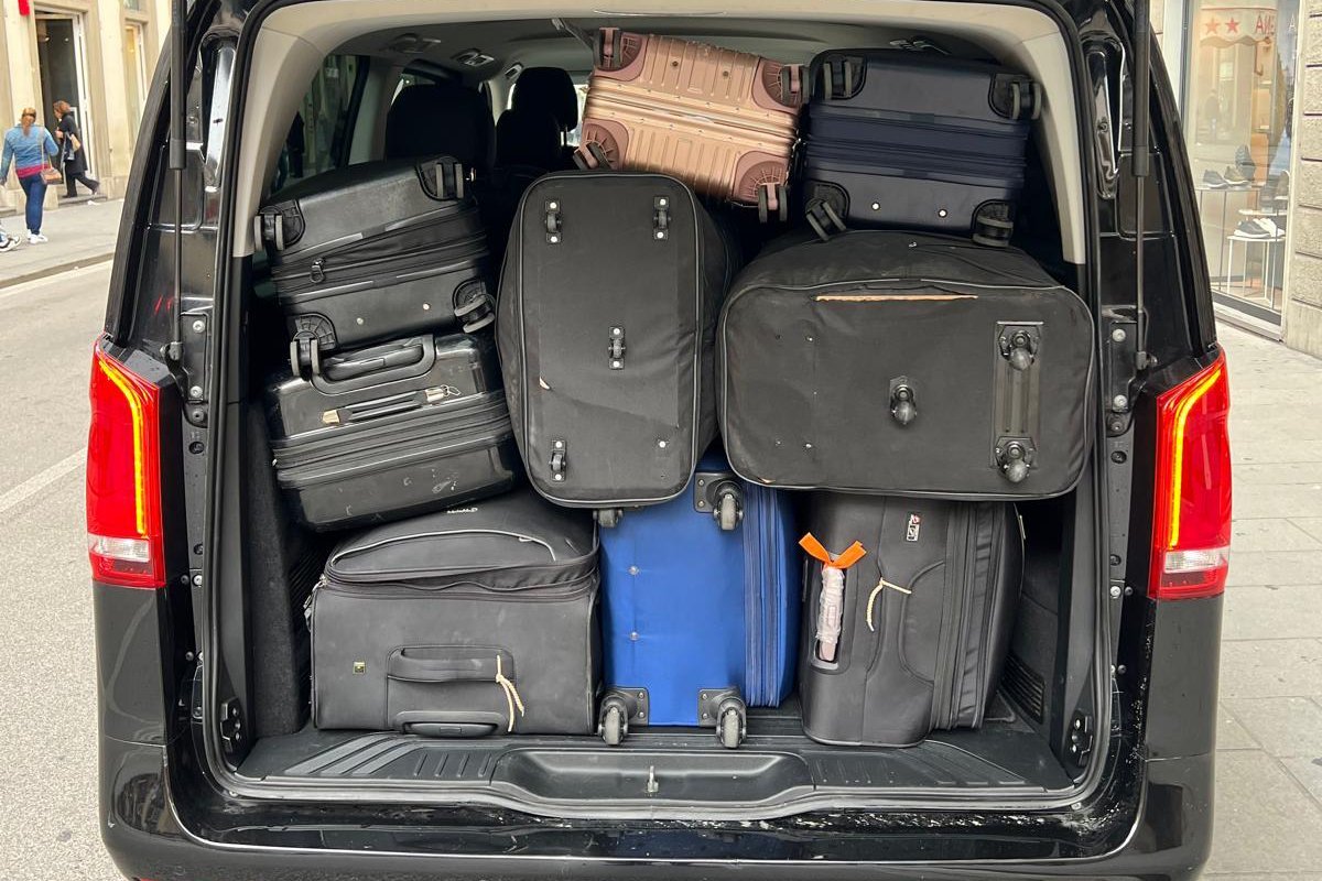 Loading passengers luggage into a Mercedes V-Class for a private transfer