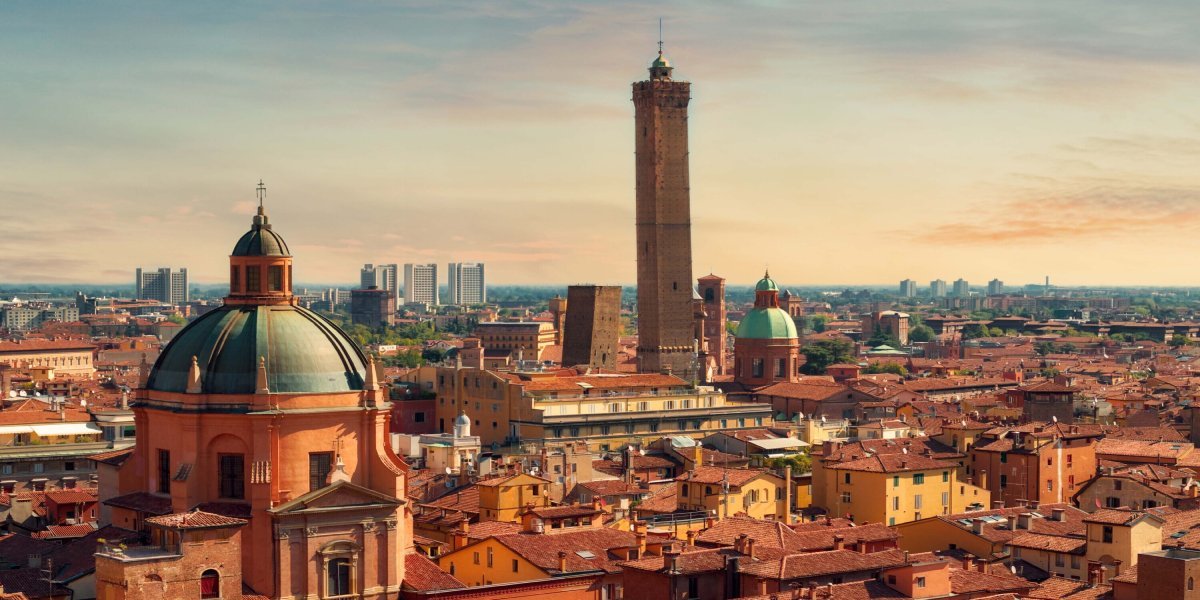 Bologna in northern Italy with mountains and waterfront buildings