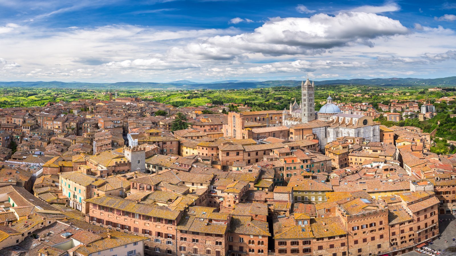 Siena in northern Italy with mountains and waterfront buildings