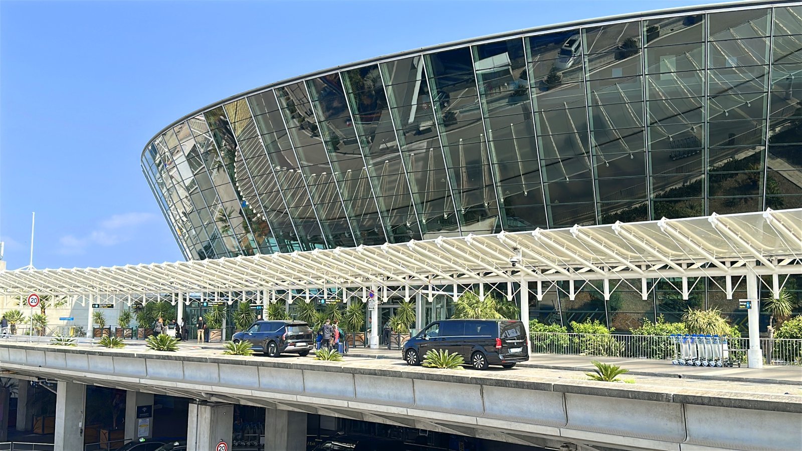 Exterior of Nice Airport Terminal 2 with passengers getting out of cars near the entrance