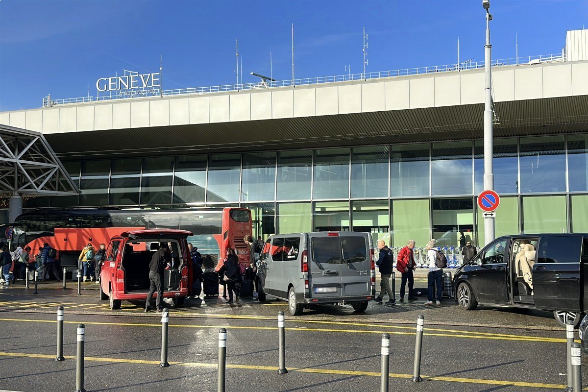 Passenger vans dropping off travelers with luggage at Geneva Airport